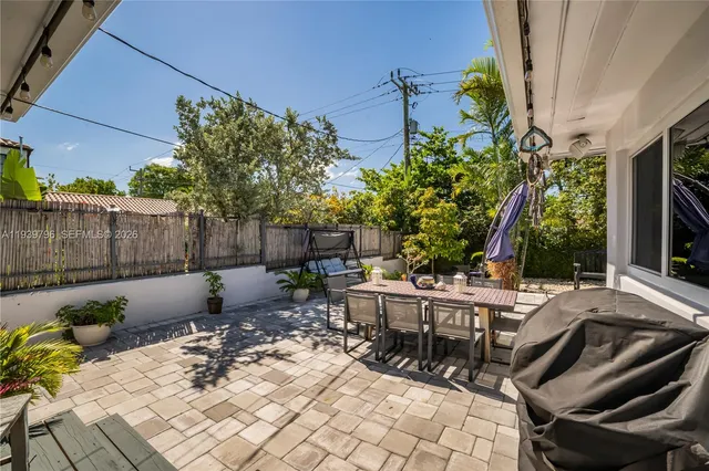 a view of a patio with table and chairs potted plants and palm tree