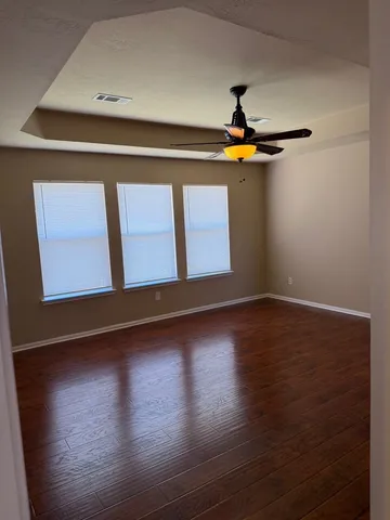 a view of an empty room with wooden floor