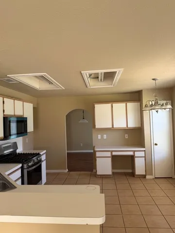 a view of an empty room with wooden floor and a ceiling fan