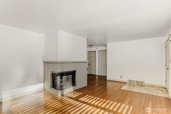 a view of a livingroom with wooden floor and a fireplace