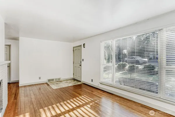 a view of a room with wooden floor and white walls