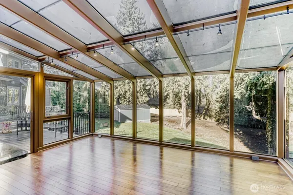 a view of an empty room with wooden floor and door