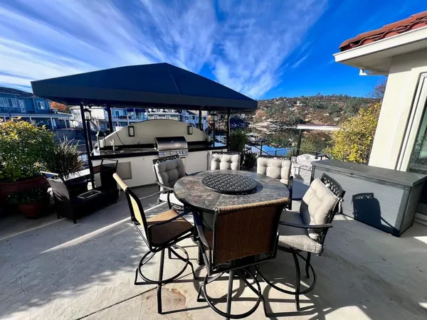 a patio with a table and chairs under an umbrella