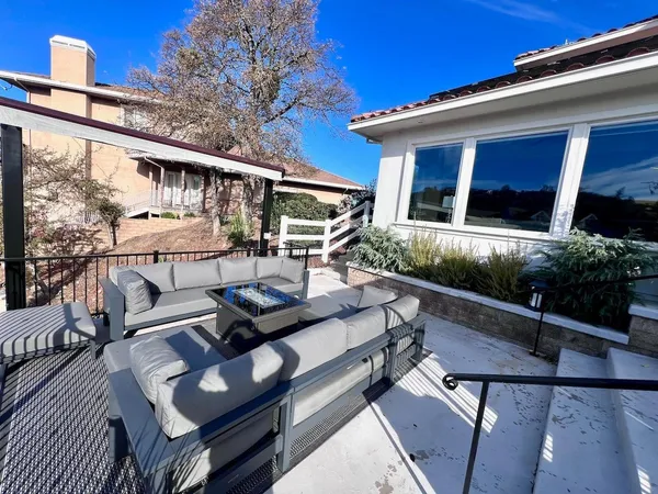 a view of a patio with couches table and chairs with wooden floor