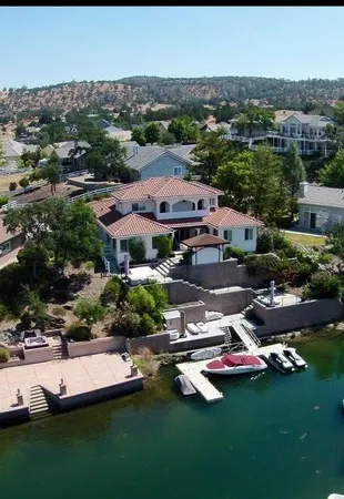 an aerial view of a house with a garden and lake view