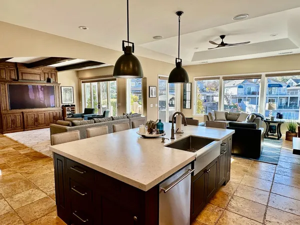 a kitchen with stainless steel appliances granite countertop a sink a counter and chairs
