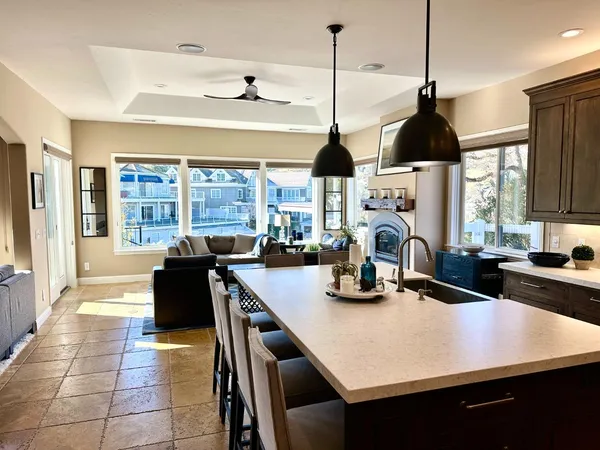 a kitchen with stainless steel appliances a stove a sink a counter space and living room view