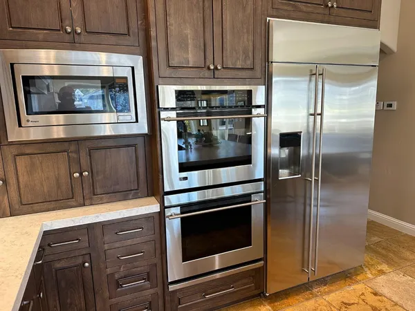 a kitchen with granite countertop white cabinets stainless steel appliances and a counter top space
