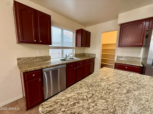 a kitchen with stainless steel appliances kitchen island granite countertop a refrigerator and stove