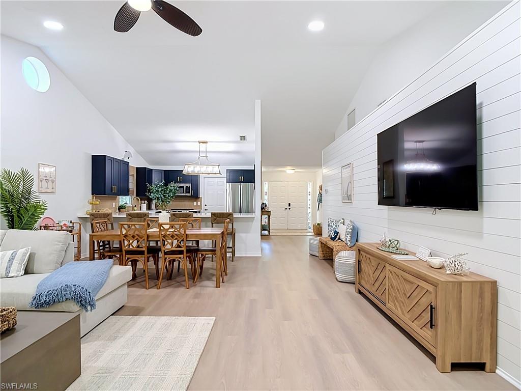 812 102nd Avenue North Naples, FL 34108 - Photo 7 of 33 Vaulted ceilings, wood-finish flooring, recessed lighting, a modern ceiling fan, and white shiplap accent wall