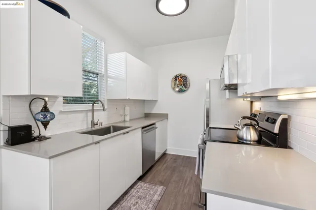 a kitchen that has a lot of cabinets and wooden floor