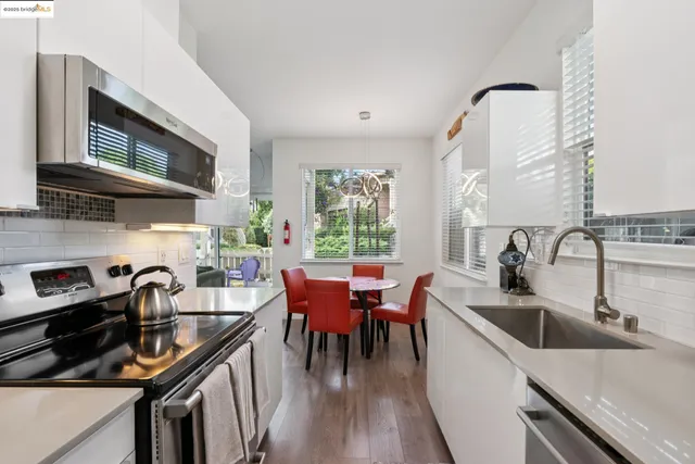 a kitchen with stainless steel appliances granite countertop a sink a stove and a wooden floors