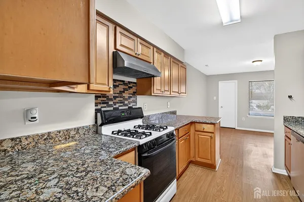 a kitchen with stainless steel appliances granite countertop a stove a sink and a refrigerator