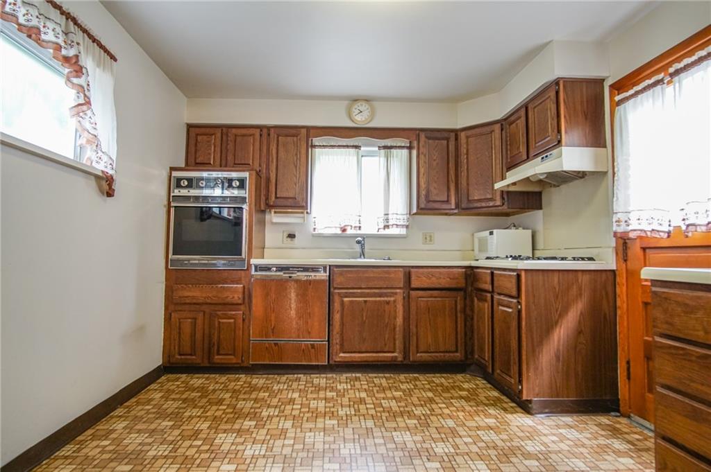 908 2nd Street McKees Rocks, PA 15136 - Photo 3 of 13 a kitchen with stainless steel appliances granite countertop a refrigerator sink and cabinets
