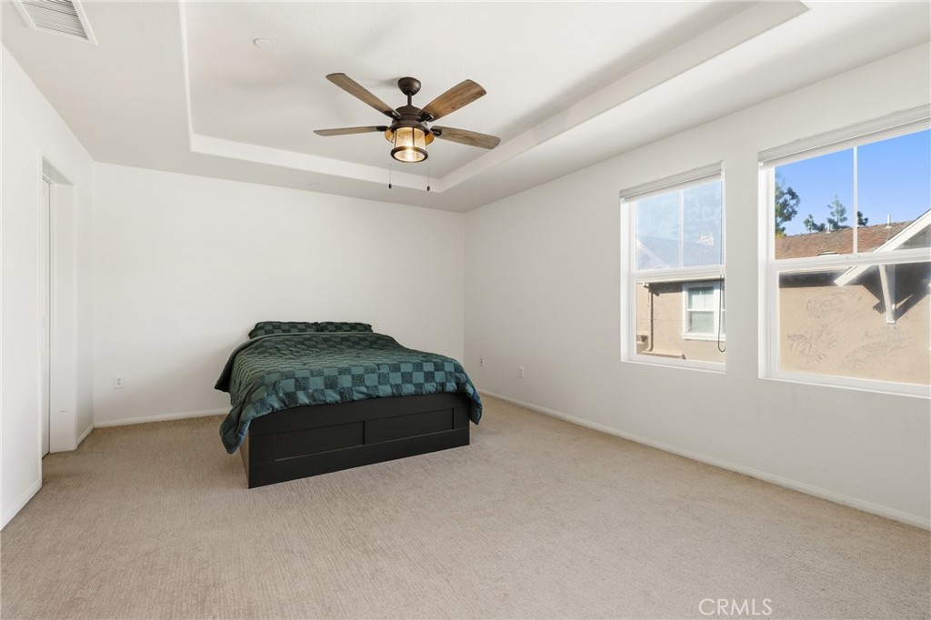 52 Valmont Way Ladera Ranch, CA 92694 - Photo 11 of 29 a bedroom with a bed and a chandelier fan