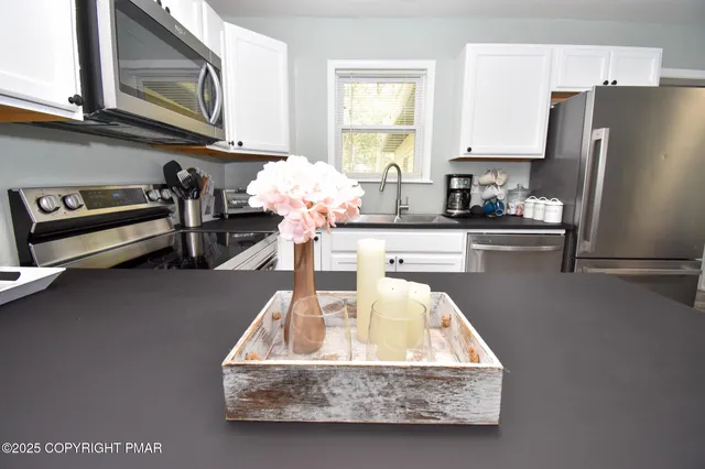 a kitchen with a refrigerator a stove a sink and a microwave