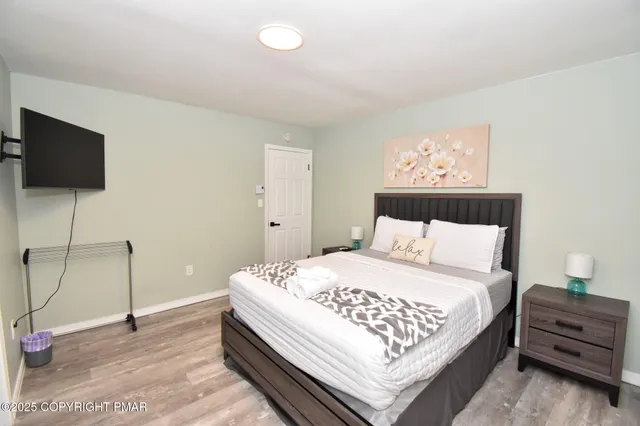 a bedroom with a bed and painting on the wall