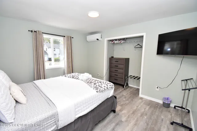 a bedroom with a bed and flat screen tv