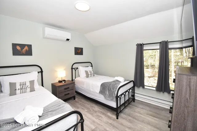 a bedroom with two beds and a painting on the wall