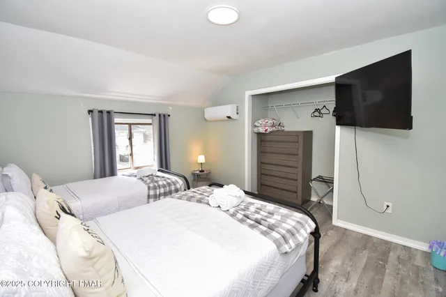 a bedroom with a bed and flat screen tv