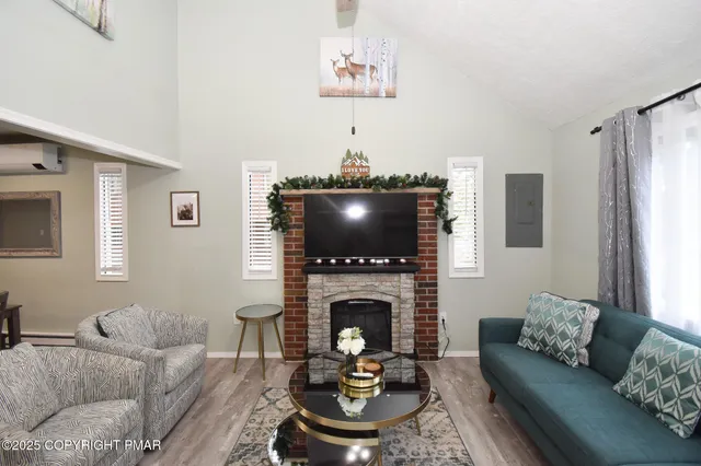 a living room with furniture a flat screen tv and a fireplace