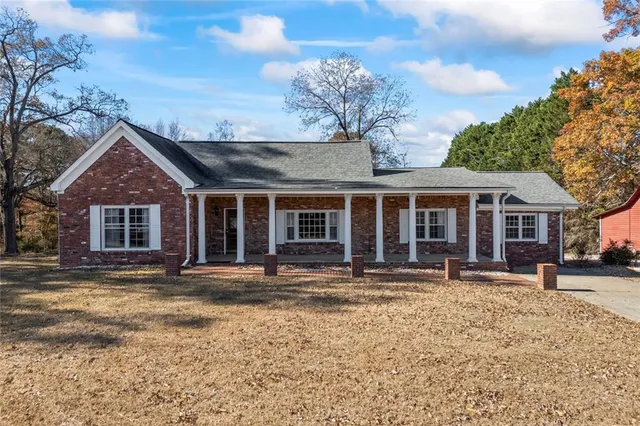a front view of a house with a yard and seating space