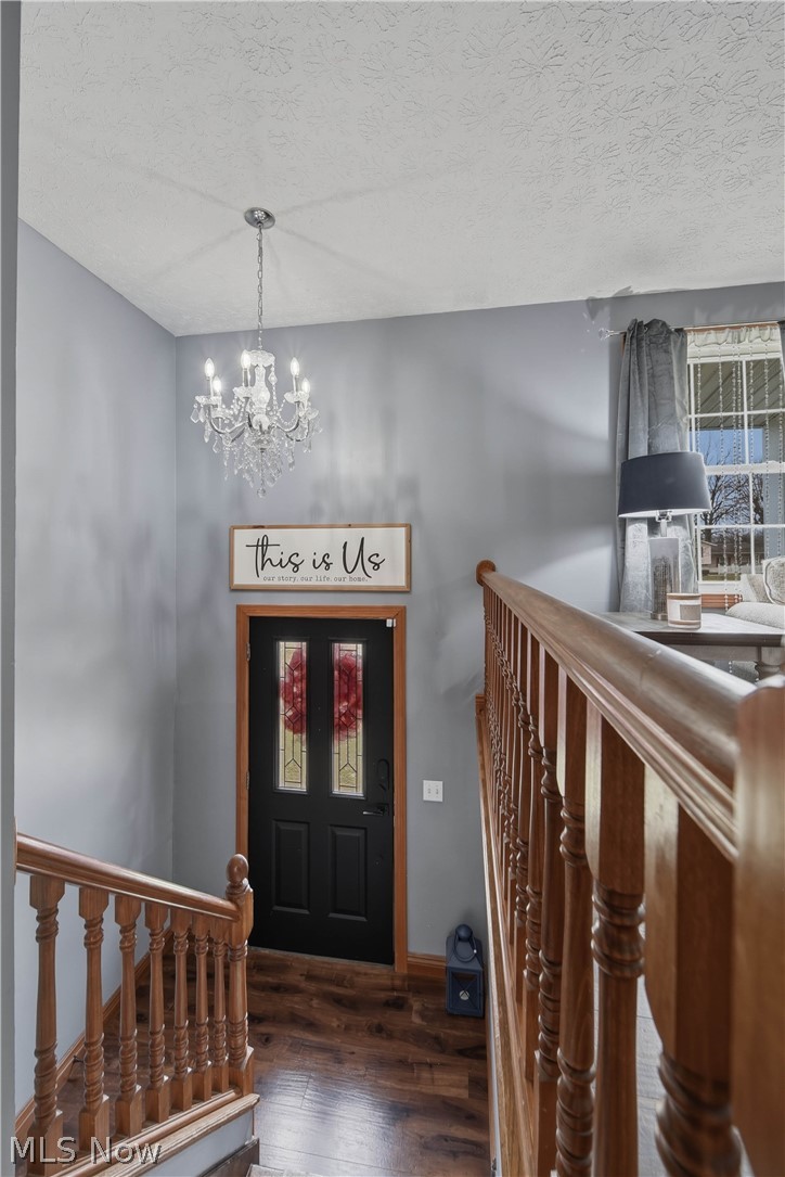 702 Perry Drive Northwest Canton, OH 44708 - Photo 15 of 46 Entrance foyer with dark wood-type flooring, a chandelier, and a textured ceiling