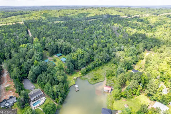 an aerial view of residential houses with outdoor space and trees