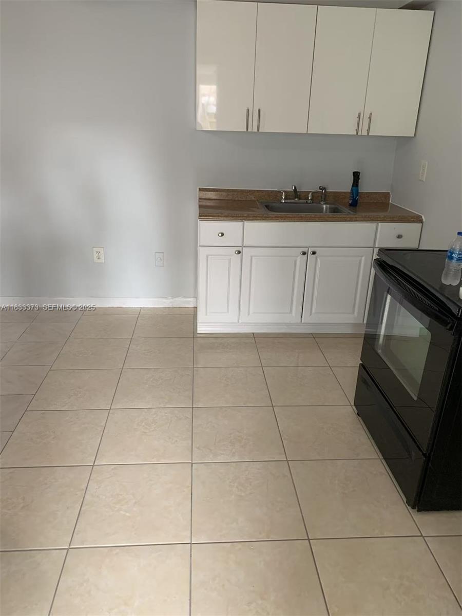 1062 West 42nd Place, Unit STUDIO Hialeah, FL 33012 - Photo 3 of 8 a kitchen with a sink and cabinets
