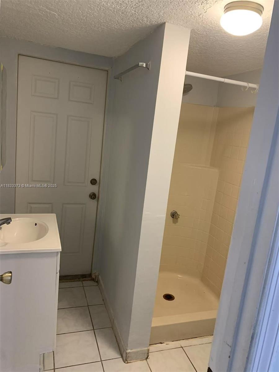 1062 West 42nd Place, Unit STUDIO Hialeah, FL 33012 - Photo 6 of 8 a bathroom with a sink a shower and a mirror