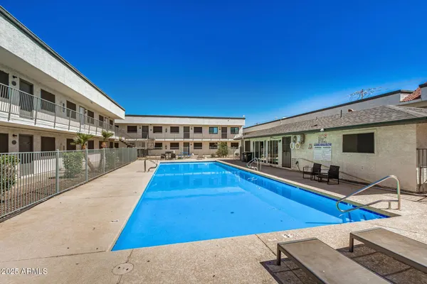 a view of a swimming pool with two chairs and a table