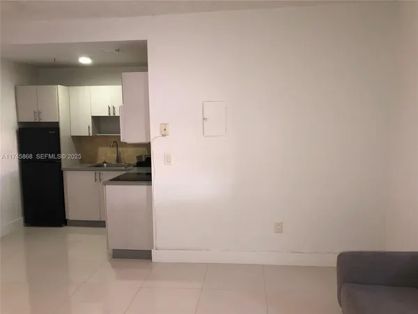 a kitchen with a refrigerator and a stove top oven