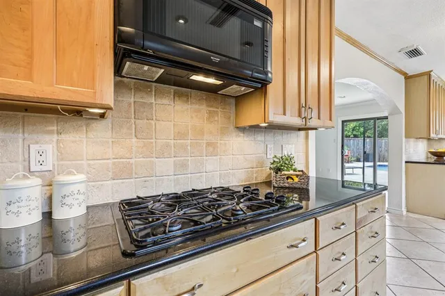 a kitchen with a stove and a white wooden cabinets