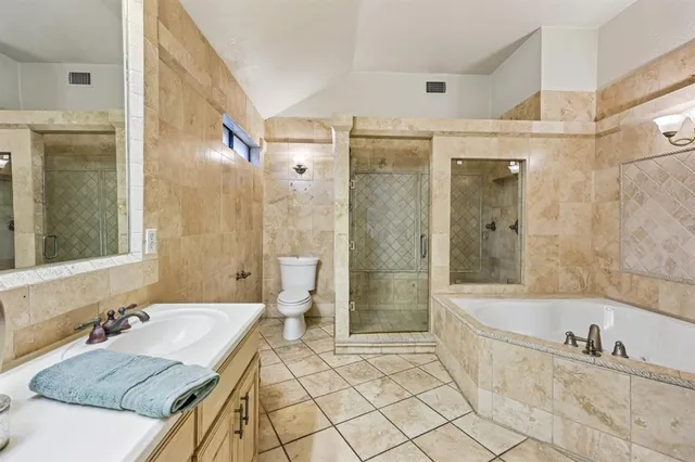 a bathroom with a granite countertop tub sink toilet and shower