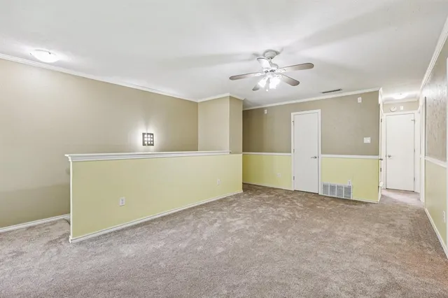 a view of an empty room with a ceiling fan