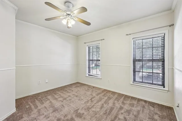a view of a big room with windows and chandelier fan