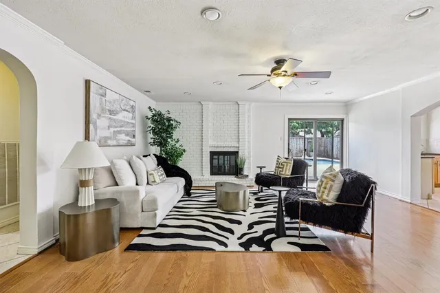 a living room with furniture ceiling fan and a wooden floor