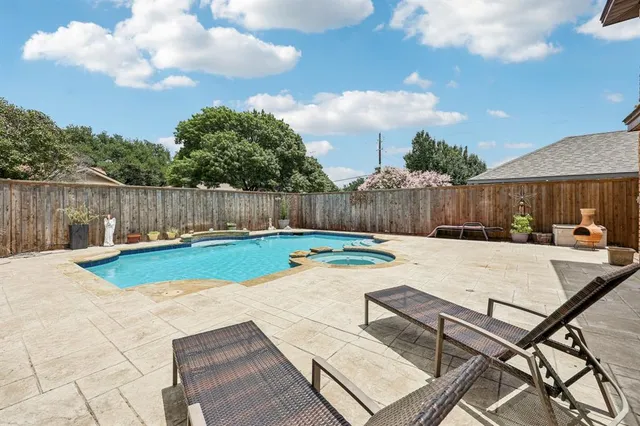 a view of swimming pool that has lawn chairs with wooden fence