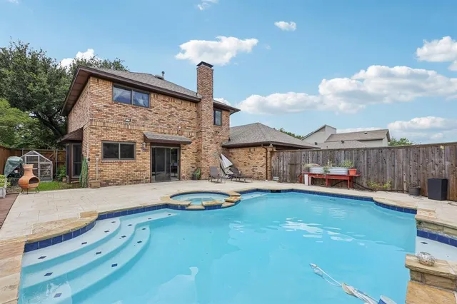 a front view of a house with swimming pool having outdoor seating
