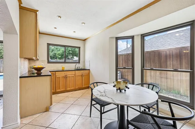 a kitchen with a table chairs sink and cabinets