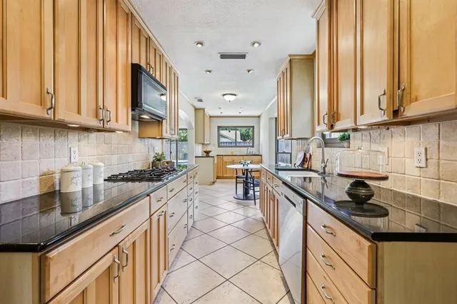 a kitchen with a sink a stove and cabinets