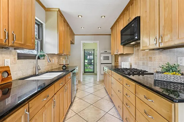 a kitchen with stainless steel appliances granite countertop a sink stove and microwave