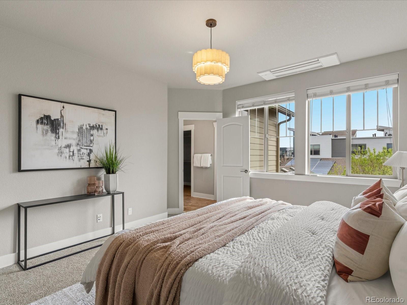 5468 Uinta Way Denver, CO 80238 - Photo 18 of 44 a bedroom with a bed and a chandelier
