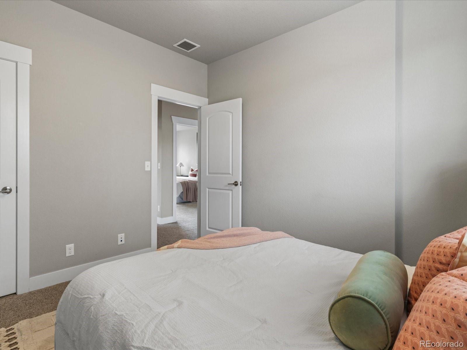 5468 Uinta Way Denver, CO 80238 - Photo 23 of 44 a bedroom with a bed and lamp