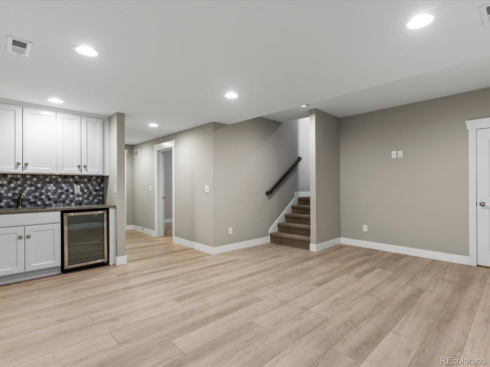 5468 Uinta Way Denver, CO 80238 - Photo 28 of 44 an empty room with wooden floor cabinet and windows