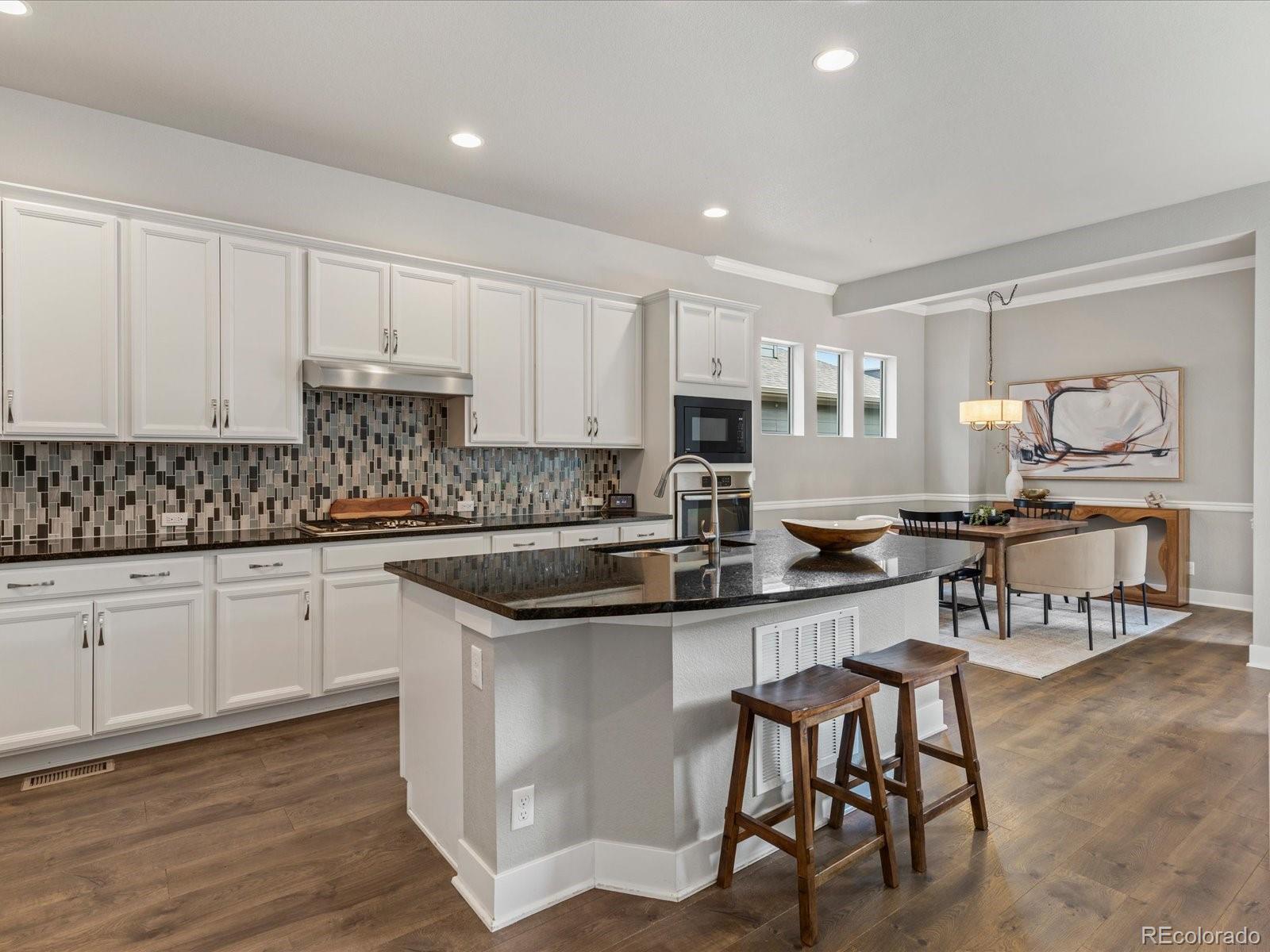 5468 Uinta Way Denver, CO 80238 - Photo 8 of 44 a kitchen with stainless steel appliances granite countertop a table chairs sink and cabinets