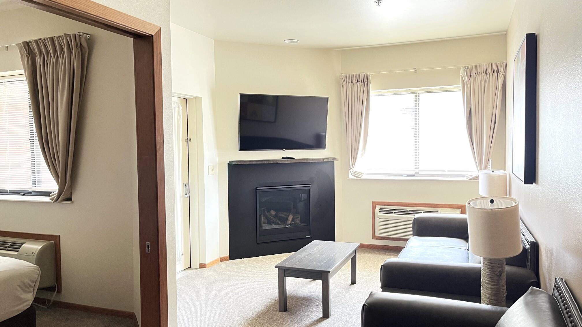 Undisclosed Address Lyons, WI 53147 - Photo 7 of 17 Newer gas fireplace & carpet. Furniture included. Doorway on near left is bedroom. Doorway to left of fireplace opens to covered patio overlooking the pool!