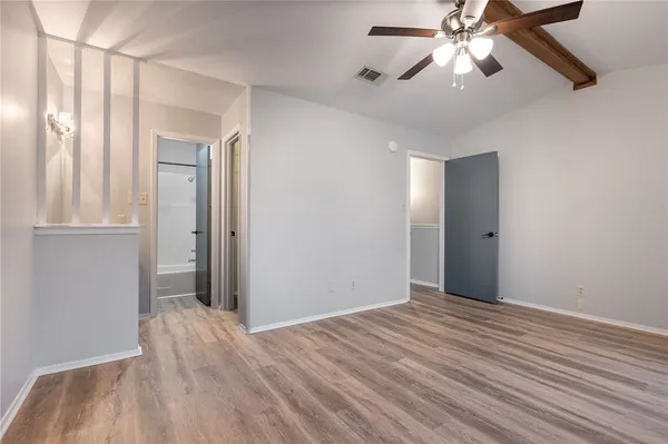 a view of empty room with wooden floor