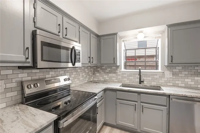 a kitchen with cabinets appliances a sink and a window