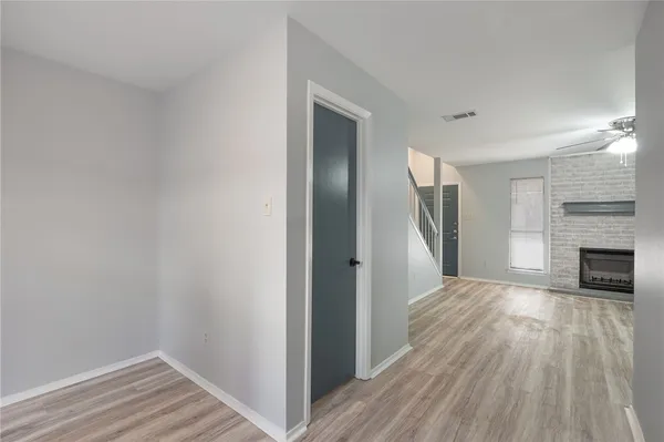 a view of a livingroom with wooden floor and a kitchen